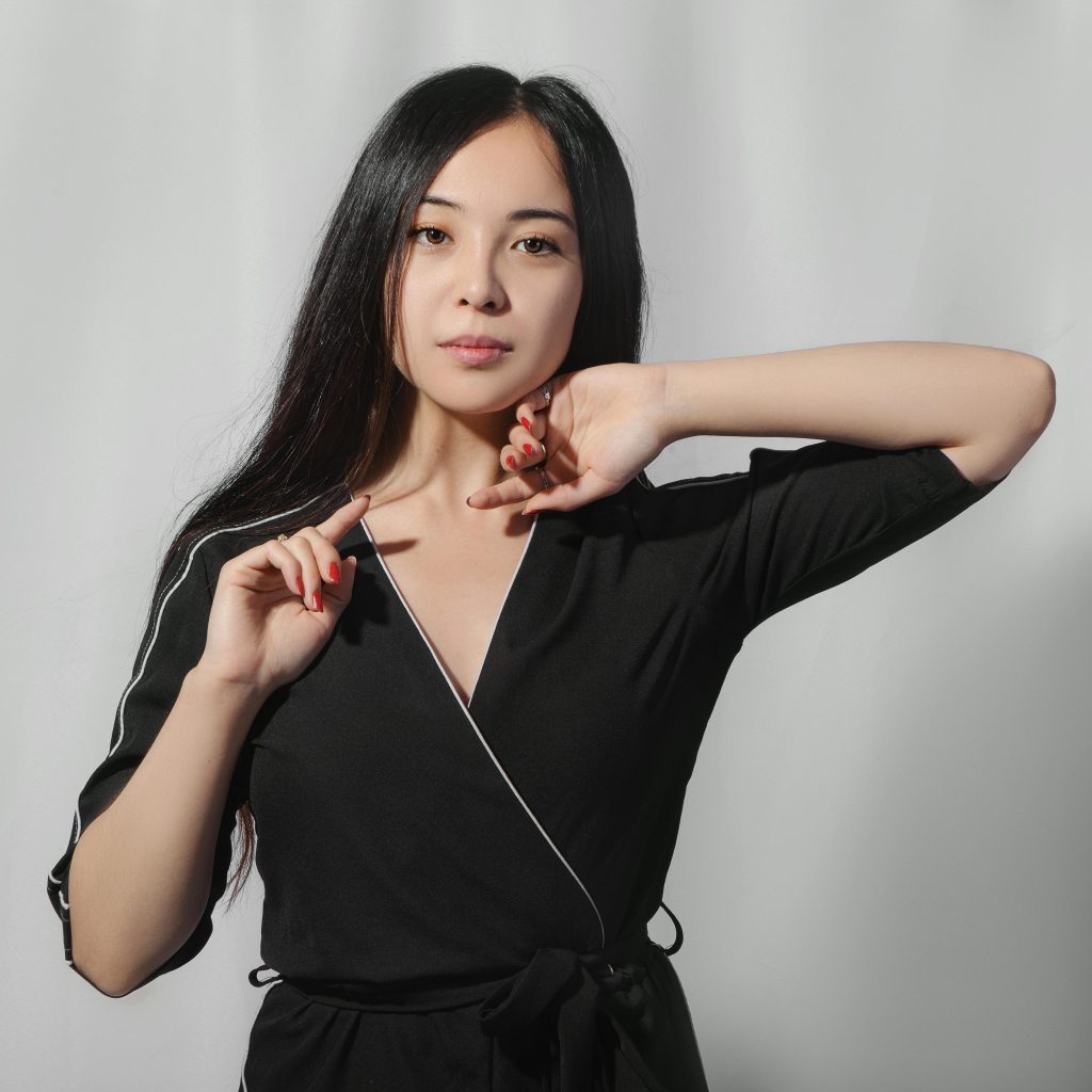 Portrait of a young woman in stylish black attire showcasing elegance and poise.